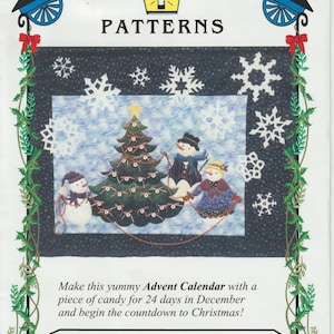 May include: A quilt pattern for a Christmas Advent calendar featuring a snowman family decorating a Christmas tree. The pattern is titled "Trimming the Tree" and the quilt size is 42" x 54".