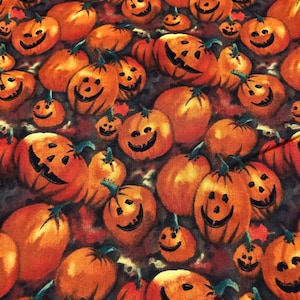 May include: A fabric pattern featuring numerous orange pumpkins with carved, smiling faces. The pumpkins vary in size and are set against a backdrop of autumn leaves, creating a festive Halloween theme.