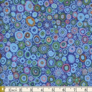 Peut inclure: Un tissu bleu avec un motif répétitif de cercles et de volutes colorés. Le tissu est mesuré avec une règle en pouces.