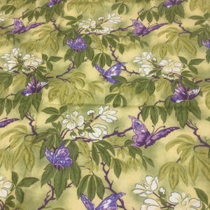 May include: A fabric with a repeating pattern of purple butterflies, white flowers, and green leaves on a pale yellow background. The design features intricate details of nature.