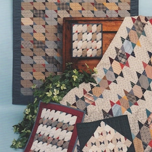 May include: A collection of handmade quilts and quilted items, showcasing various patterns and designs. The quilts feature a mix of fabrics in neutral tones, with accents of red, blue, and other colors. The text "SEW SO EASY" is at the top.