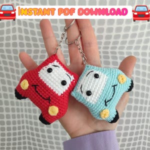 May include: Two handmade crochet car keyrings, one red and one light blue, with white and black details. Each keyring has a smiling face and yellow accents. The text "INSTANT PDF DOWNLOAD" is at the top.