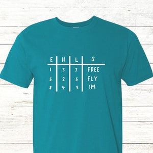 May include: Teal t-shirt with a white grid and numbers on the front. The text "TEXT HERE" is on the back of the shirt.
