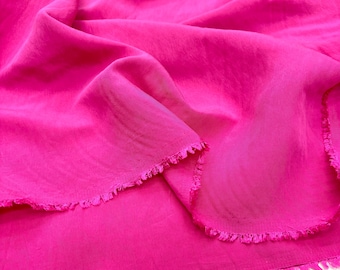 Puede incluir: Tela rosa brillante, posiblemente seda o un material similar, con una caída suave y fluida. La tela está arrugada, mostrando pliegues y un borde deshilachado. El color intenso y la textura delicada sugieren su uso para prendas o elementos decorativos.