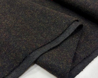 May include: Close-up of a dark brown fabric with a textured, speckled appearance. The material has a dense weave with hints of green and red throughout. The edges of the fabric are folded over, revealing a darker, solid backing.