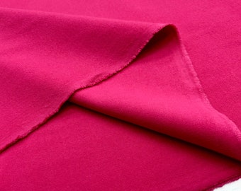 May include: A close-up of a folded piece of fabric in a vibrant magenta colour. The fabric has a soft, slightly textured surface.
