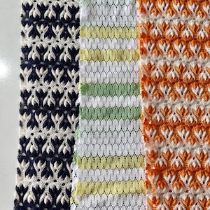 Puede incluir: Tres muestras de tela con diferentes patrones. La primera muestra es un patrón de encaje azul marino y blanco. La segunda muestra es un patrón de encaje a rayas blanco y verde. La tercera muestra es un patrón de encaje naranja y blanco.