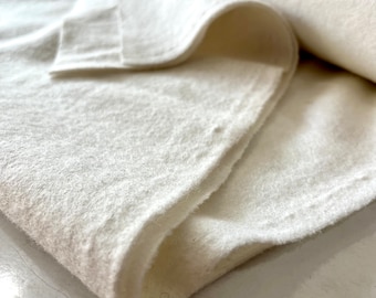 May include: White fabric with a soft, fuzzy texture. The fabric is folded in half and the edges are visible.
