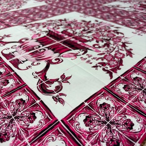 Può includere: Primo piano di un tessuto bianco e bordeaux a motivi floreali. Il design presenta fiori e foglie stilizzati all'interno di una griglia di quadrati. La tavolozza dei colori comprende sfumature di bordeaux, rosa e bianco, creando un'estetica vintage. Il tessuto è probabilmente utilizzato per l'arredamento della casa.