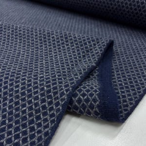 Könnte beinhalten: Ein Nahaufnahme eines dunkelblauen Stoffes mit einem weißen Rautenmuster. Der Stoff ist weich und strukturiert und eignet sich perfekt für eine Vielzahl von Projekten.