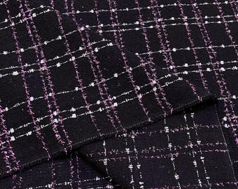 May include: Black fabric with a white and pink checkered pattern. The fabric has a textured, woven look.