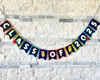 May include: A rainbow-coloured banner with black felt pennants that spell out "Class of 2025". Each pennant has a small graphic of an apple or a pencil.