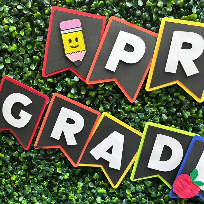 K&ouml;nnte beinhalten: Ein farbenfroher Filzbanner mit dem Wort "GRAD" und einem Bleistift mit einem Smiley. Der Banner ist perfekt f&uuml;r eine Abschlussparty oder eine Klassendekoration.