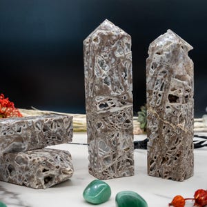 May include: Two brown and white marble stone towers with a pointed top, and two smaller pieces of the same stone. The towers are about 6 inches tall and the smaller pieces are about 3 inches long. The stones have a unique pattern of white veins running through them.