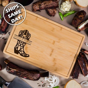 May include: Personalized bamboo cutting board with a laser engraved design of a cowboy boot with floral details. The text "Chuck & Denise" is engraved above the boot.