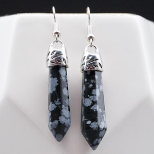 May include: A pair of silver dangle earrings with black and white snowflake obsidian stone drops.