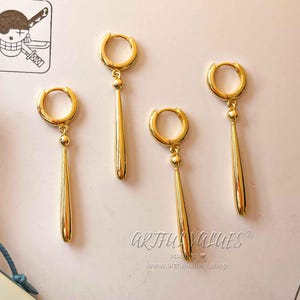 Peut inclure: Ensemble de quatre boucles d'oreilles pendantes dor&eacute;es avec un design de cercle simple et une longue goutte fine et pointue.