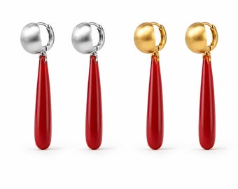 May include: Two pairs of drop earrings featuring a brushed metal hoop top and a long, smooth, bright red teardrop-shaped pendant. One pair is finished in a silver tone, while the other pair is finished in a gold tone, both with a hinged closure.