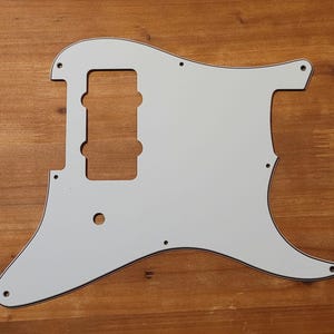 以下が含まれることがあります： シングルピックアップのカットアウトとコントロールノブの穴のある白いギターピックガード