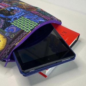 以下が含まれることがあります： ステンドグラス柄のカラフルなジッパー付きポーチで、タブレットと本が入っています。本は赤色で、背表紙に「TIME」と印刷されています。