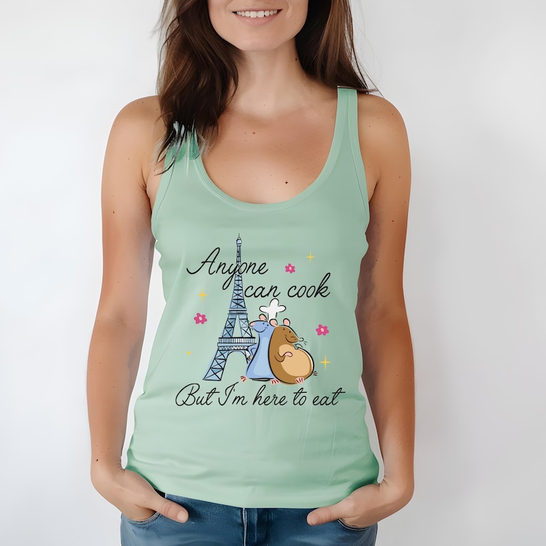 May include: A light green tank top with a graphic of two cartoon rats in front of the Eiffel Tower. The text on the shirt reads "Anyone can cook but I'm here to eat."