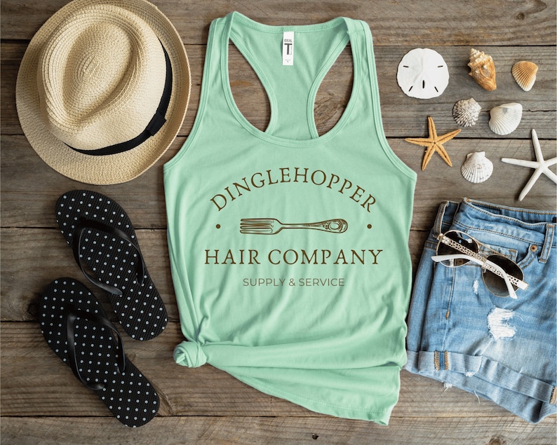 Peut inclure: Un d&eacute;bardeur vert menthe avec un graphique brun qui dit "Dinglehopper Hair Company Supply & Service" avec un dessin d'une fourchette.
