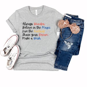 May include: Gray t-shirt with the text "Always Wonder Believe in the Magic Live the Fantasy Share your Dream Make a Wish" in colorful lettering.