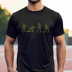 Puede incluir: Una camiseta negra con un gr&aacute;fico de cinco soldados de juguete verdes en diferentes poses. Los soldados sostienen armas y est&aacute;n en fila.