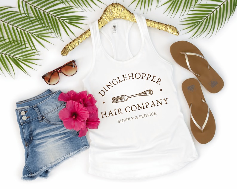 Peut inclure: Un d&eacute;bardeur blanc avec un graphique brun qui dit "Dinglehopper Hair Company Supply & Service" avec un dessin d'une fourchette.