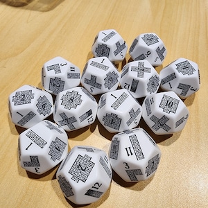 May include: A set of 12 white dice with black numbers and symbols. Each die has 12 sides and features a different combination of numbers and symbols.