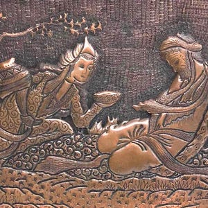 May include: A copper-coloured relief carving showing two figures in detailed attire. One figure presents a bowl to the other, who is seated. A tree and decorative patterns are also visible. The artwork likely represents a historical or cultural scene.