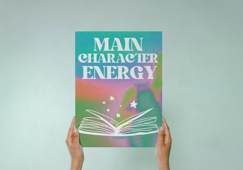 May include: A teal, pink, and green poster with the text "MAIN CHARACTER ENERGY" in white. The poster features a white outline of an open book with stars above it.