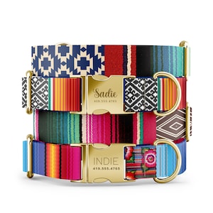 May include: Three colorful dog collars with gold buckles and engraved names. The top collar is blue, white, and red with the name "Sadie" and phone number "419.555.4765". The middle collar is turquoise, pink, and green. The bottom collar is blue, pink, yellow, and red with the name "Indie" and phone number "419.555.4765".