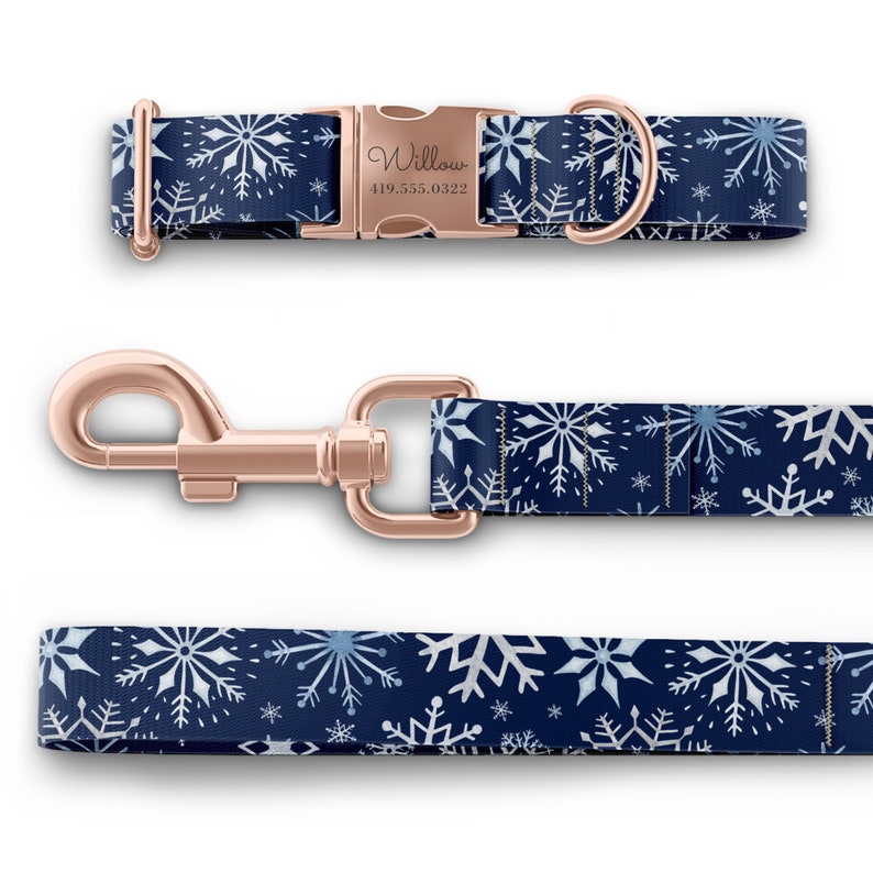 Peut inclure: Un collier et une laisse pour chien bleus avec un motif flocon de neige. Le collier a une boucle en or rose avec le nom "Willow" et un num&eacute;ro de t&eacute;l&eacute;phone grav&eacute; dessus.