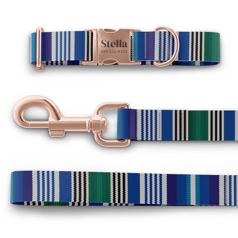 May include: A dog collar, leash, and matching leash set. The collar features a rose gold buckle engraved with "Stella" and a phone number. The set has a blue, white, and green striped pattern.
