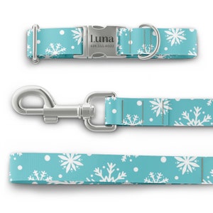 Peut inclure: Un collier et une laisse pour chien bleus avec un motif de flocons de neige blancs. Le collier a une boucle argent&eacute;e avec le nom "Luna" et un num&eacute;ro de t&eacute;l&eacute;phone grav&eacute; dessus.