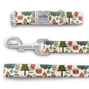 May include: A white dog collar and leash with a camping themed pattern. The pattern features a blue and red camper, a green pine tree, a red camp chair, a red cooler, a campfire, and a lantern. The collar has a silver buckle with the name "Stella" and a phone number.