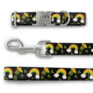 K&ouml;nnte beinhalten: Ein schwarzes und gr&uuml;nes Hundehalsband und eine Leine mit einem Regenbogen- und Leprechaun-Hut-Muster. Das Halsband hat eine silberne Schnalle mit dem Namen "LUCY" und der Telefonnummer "419.555.0322" eingraviert.