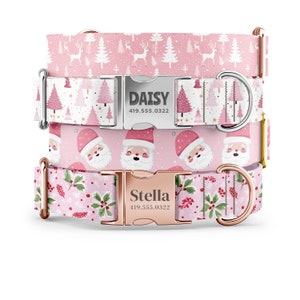 May include: Two pink dog collars with silver and rose gold buckles. The top collar has a white background with pink Christmas trees and reindeer. The bottom collar has a pink background with a red and white Santa Claus pattern. Both collars have personalized name tags with phone numbers.