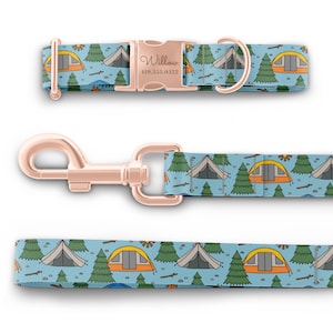 May include: A blue and green dog collar and leash set with a camping theme. The collar has a rose gold buckle with the name "Willow" and a phone number engraved on it. The leash has a rose gold clip.