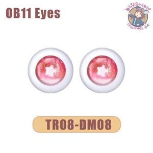 Peut inclure: Une paire d'yeux de poupée rose et blanc avec une pupille en forme d'étoile. Les yeux sont étiquetés "OB11 Eyes" et "TR08-DM08".