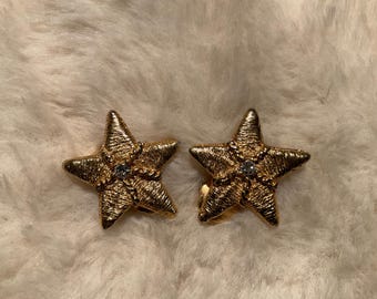 Gold plated star clip on earrings with a clear rhinestone.