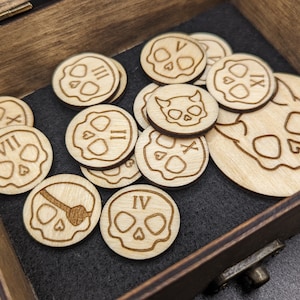 May include: A wooden box filled with 10 round wooden tokens. Each token features a skull design with Roman numerals I through X. The box is made of dark wood with a hinged lid.