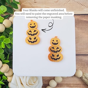May include: Two unfinished pumpkin-shaped blanks with glittery orange surfaces and carved jack-o'-lantern faces. The text reads: "Your Blanks will come unfinished. You will need to paint the engraved area before removing the paper masking."