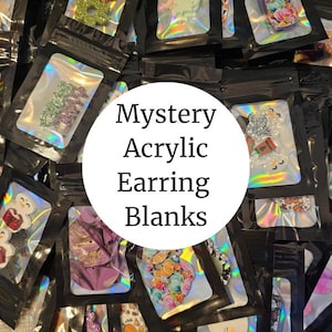 May include: A collection of small, sealed black bags filled with various acrylic earring blanks. The bags have a holographic sheen. The text "Mystery Acrylic Earring Blanks" is in a white circle in the center of the image.