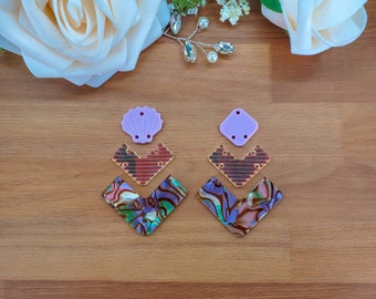 May include: A pair of earrings with a layered design. The earrings are made of iridescent shell, red and brown patterned plastic, and purple plastic. The earrings are shaped like a chevron.
