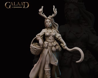 May include: A miniature figurine of a female figure with antlers, holding a basket and a sickle. She is wearing a long dress and a belt with a pouch. The figurine is painted in a light brown color.