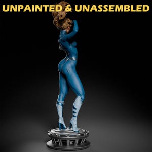 May include: Unpainted and unassembled blue plastic figurine of a woman in a blue jumpsuit and boots standing on a circular base.