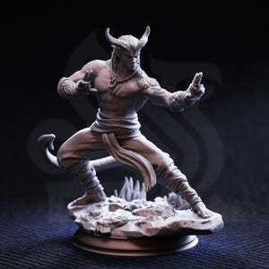May include: A detailed figurine of a muscular humanoid figure with horns, a tail, and intricate tattoos. The figure is in a dynamic pose, set on a rocky base. The color palette is monochromatic, with shades of gray and white.