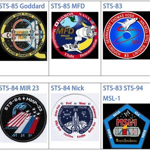 May include: A collage of nine NASA space shuttle mission patches. The patches are circular, hexagonal, and octagonal in shape. They feature a variety of colours, including red, blue, white, yellow, and black. The patches depict the space shuttle, the Earth, and other space-related imagery. The text on the patches includes the mission number, the names of the astronauts, and the mission objectives.